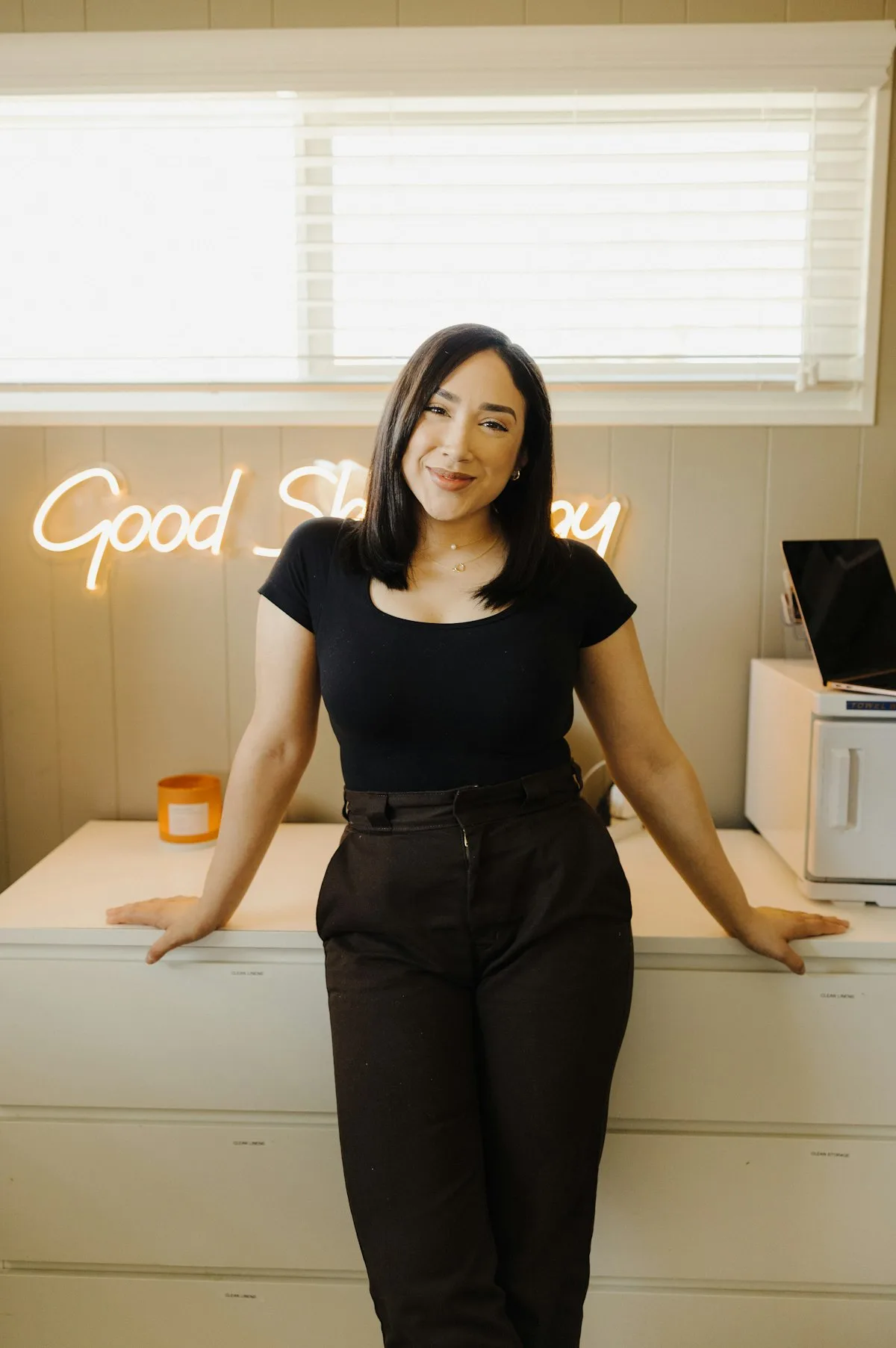 A happy salon owner standing at the counter in her salon